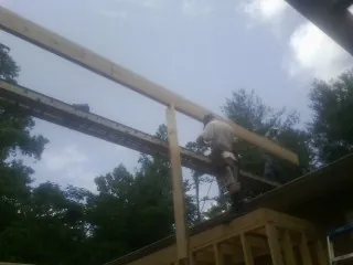 Carpenter setting a ridge beam over a new addition frame — Ice Dam Removal by Roofing Brothers in Bellefontaine
