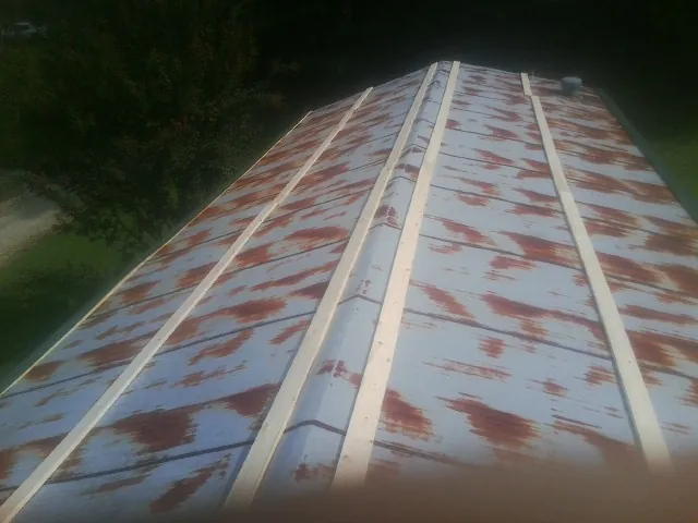 Rusted metal roof panels with new wood purlins before replacement — Storm Damage Roof Repair in Bellefontaine by Roofing Brothers